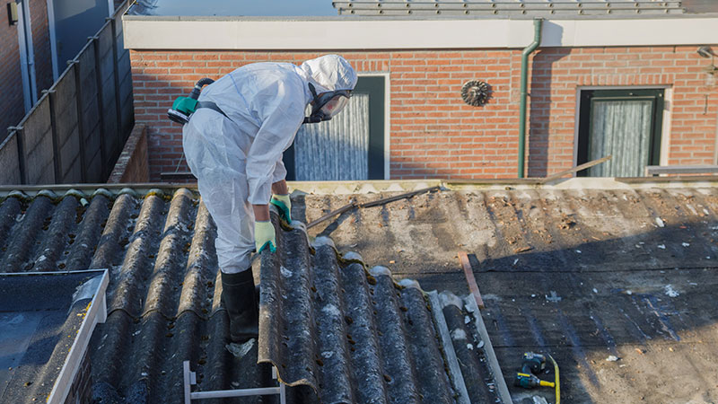 técnico a remover amianto da cobertura de uma habitação